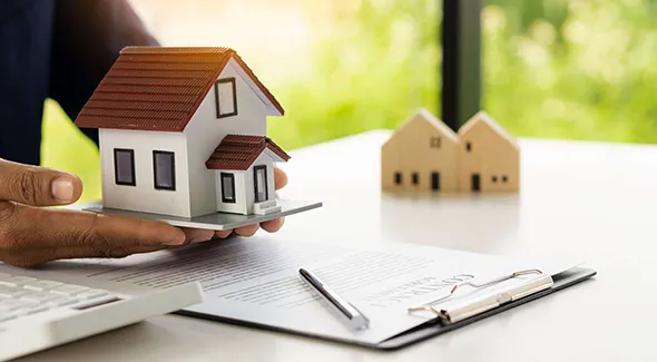 A dedicated real estate agent working in the office, reviewing property listings and assisting clients with expert advice