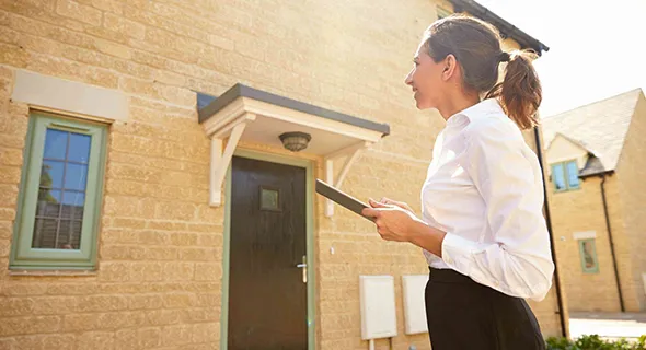 Property valuation specialists standing out side the home , smiling and ready to assist with property assessments.