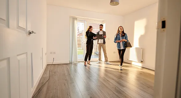 Local property evaluation expert showing a home to a couple, providing expert insights on the property’s value.