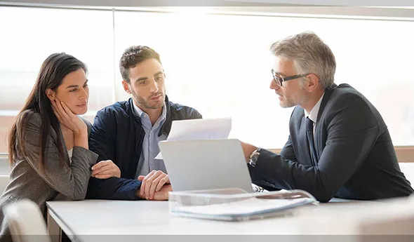 Property evaluation expert giving expert advice to a couple at home about their property's value.