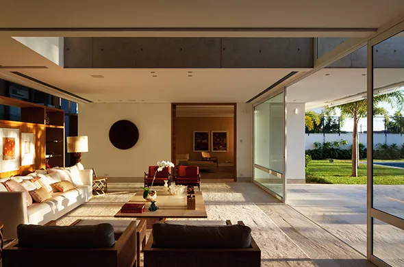 Stylish living room with expansive windows and a patio, highlighting contemporary design in a high-end property.